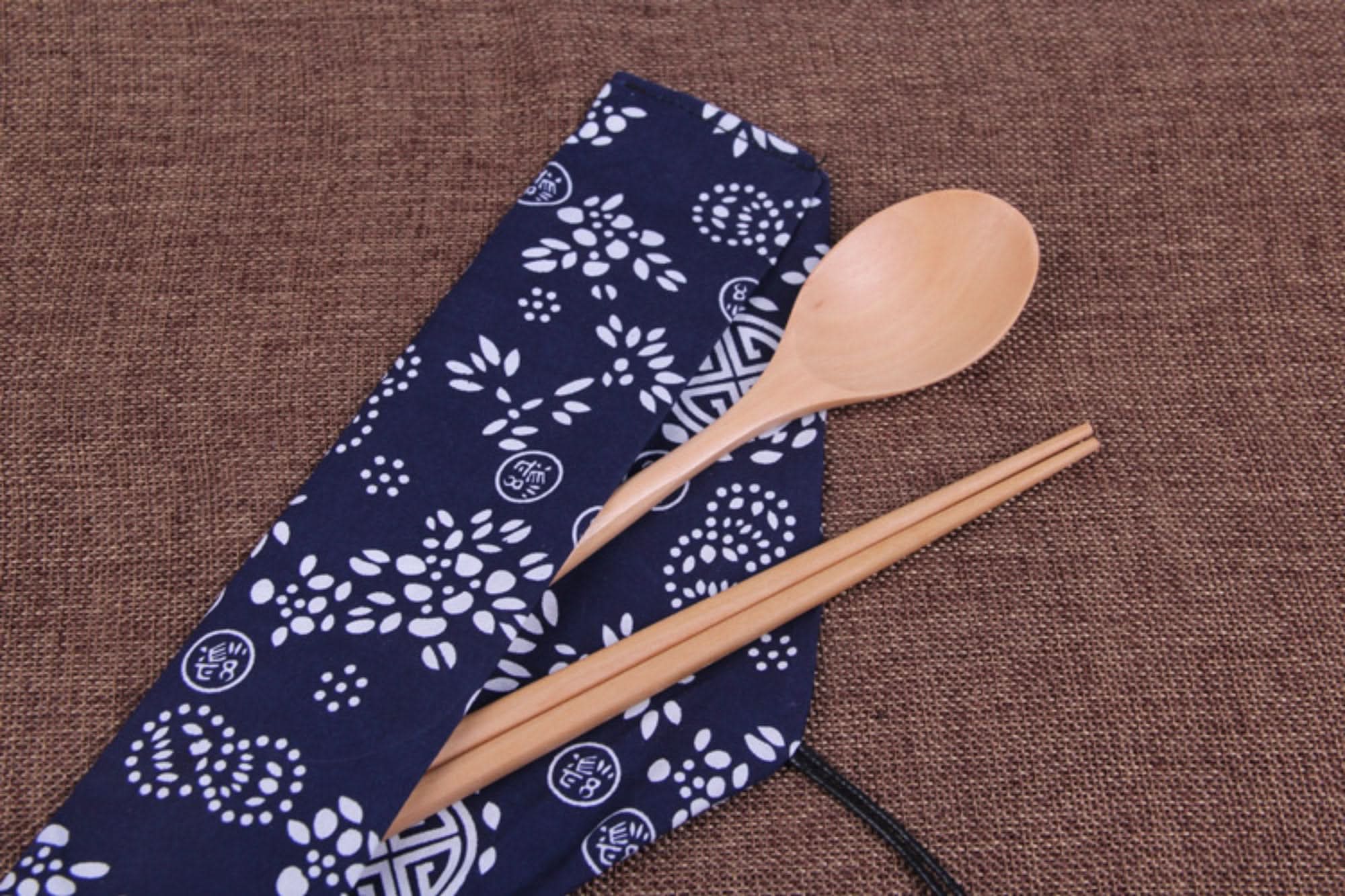Natural wooden Japanese wood cooking utensils with spoon set & fabric case on brown burlap.